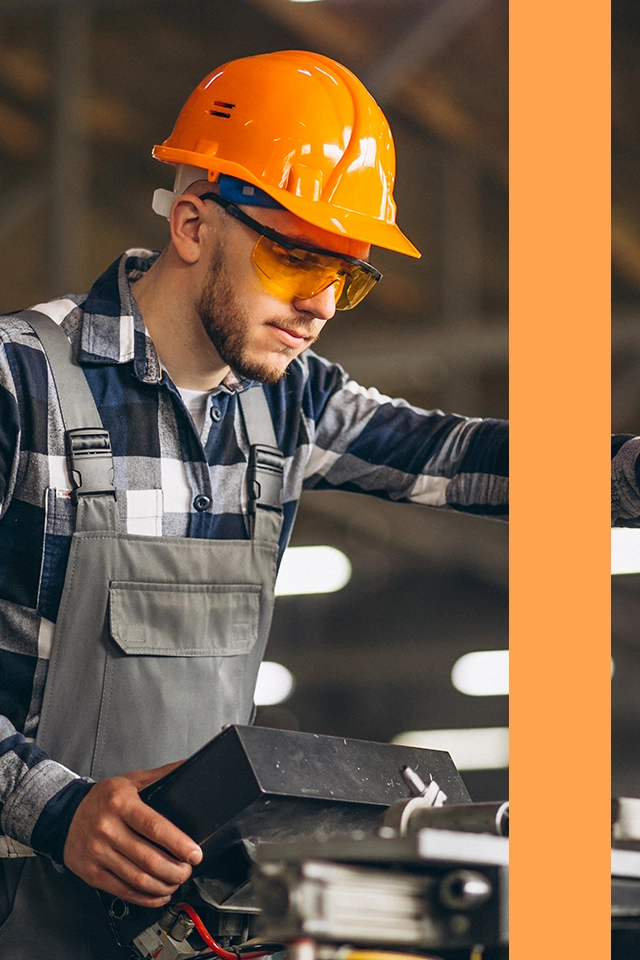 Man i hardhat som arbetar i en fabrik.