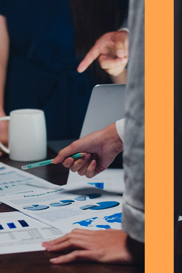 Man som riktar en penna mot en företagsrapport.