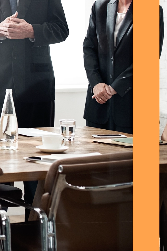 En styrelse som står runt ett mötesbord.